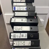 Stack of 9 Black Lever Arch Files with Labels